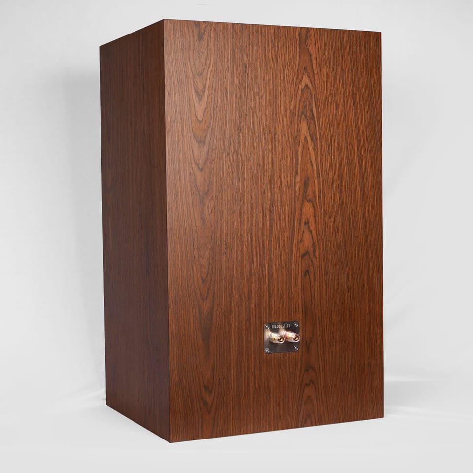 Rear three-quarter view of a large wood-grain Gema cabinet with a recessed sbacoustics two-post terminal plate