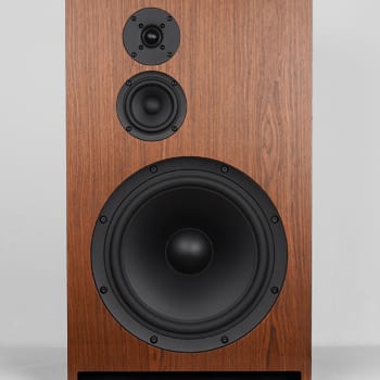Gema speaker front view: wood veneer cabinet with dome tweeter, midrange cone, large woofer and slot port.