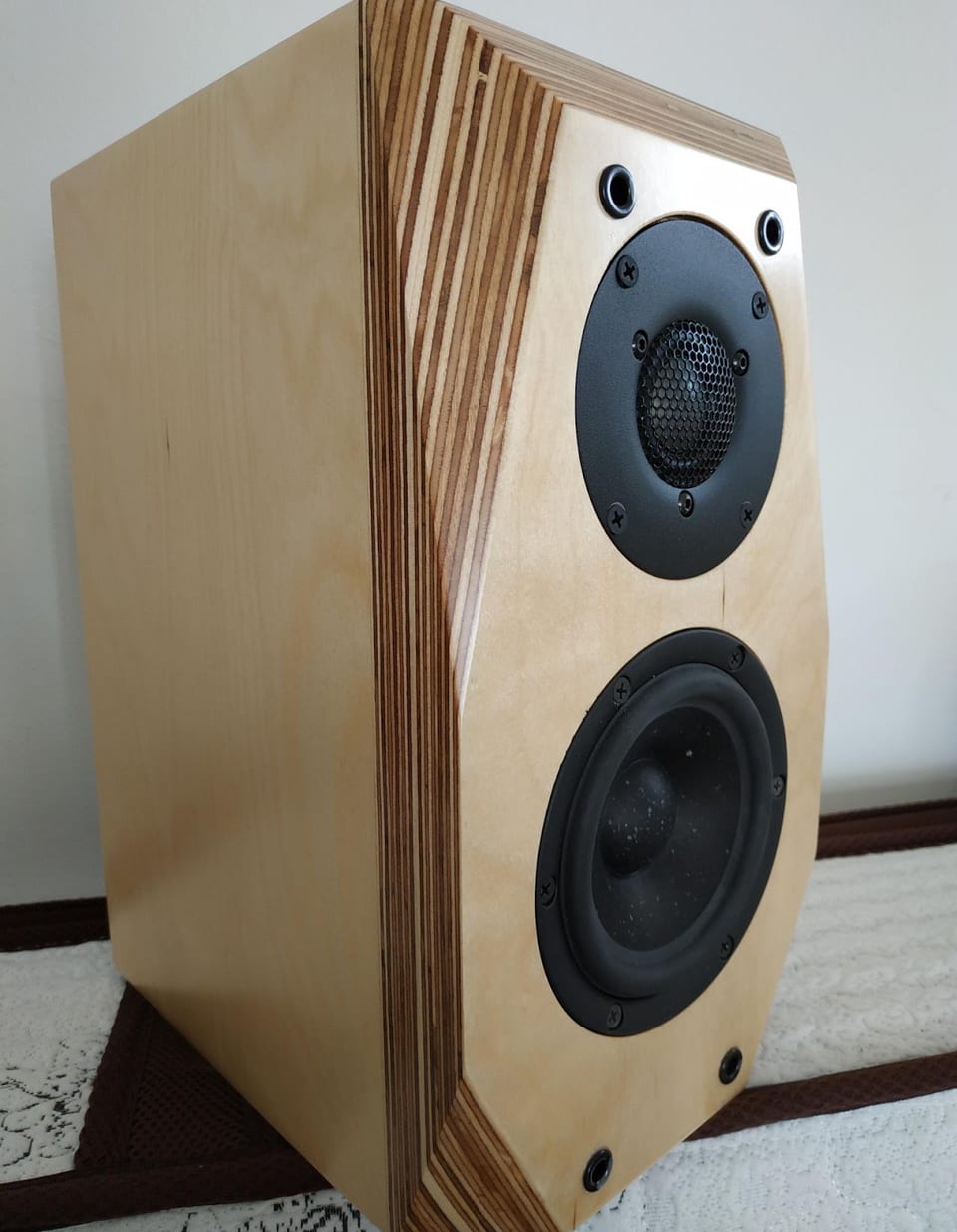 Revolution Mini Be in birch plywood: mesh-protected dome tweeter above a speckled-cone midwoofer.